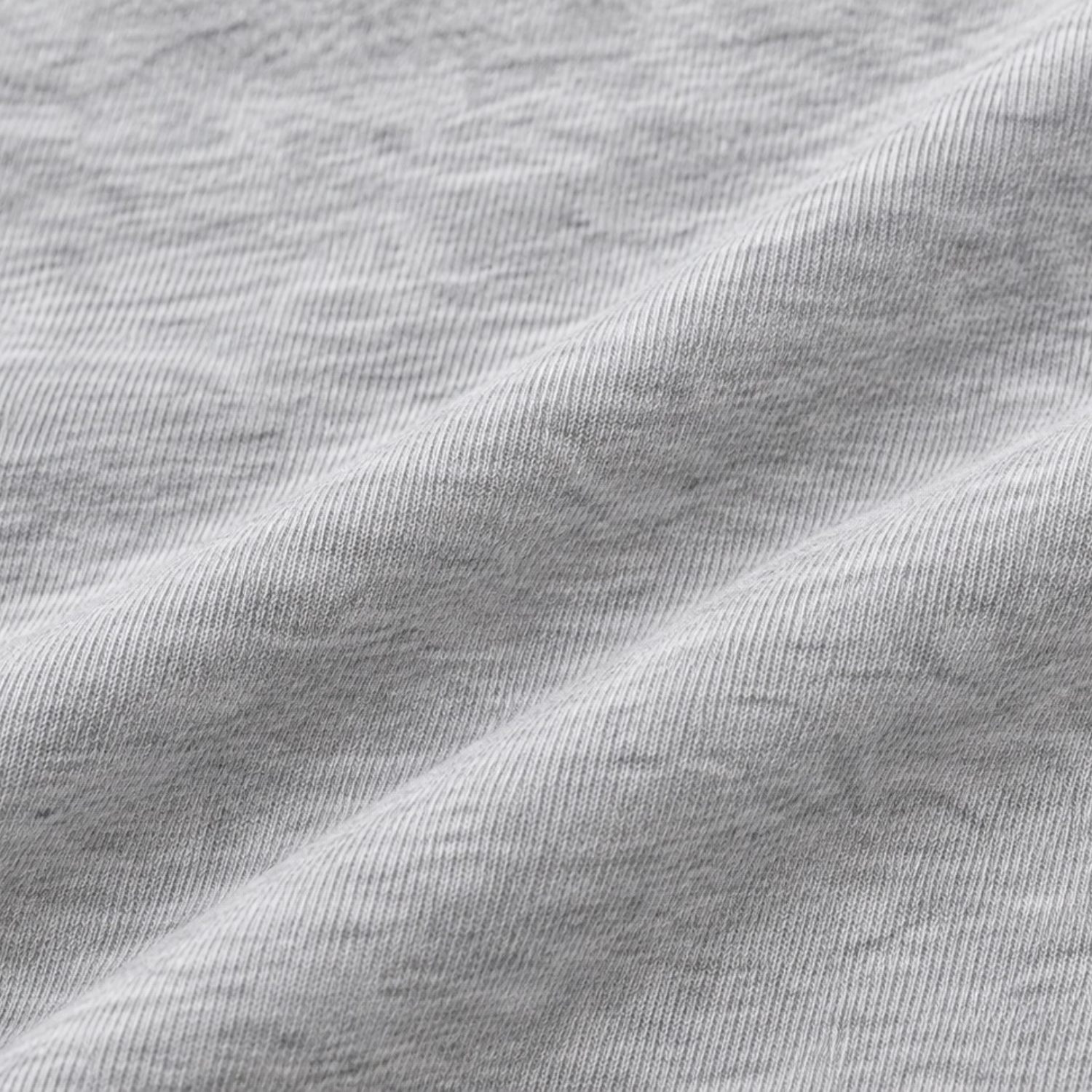 A close-up of light gray heathered fabric with soft diagonal folds showing the knit texture.