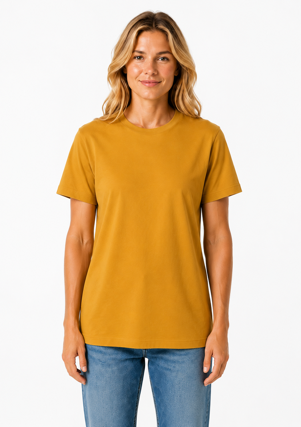 A woman with blonde hair wearing a mustard yellow short-sleeve crewneck t-shirt and blue jeans, standing against a plain white background.