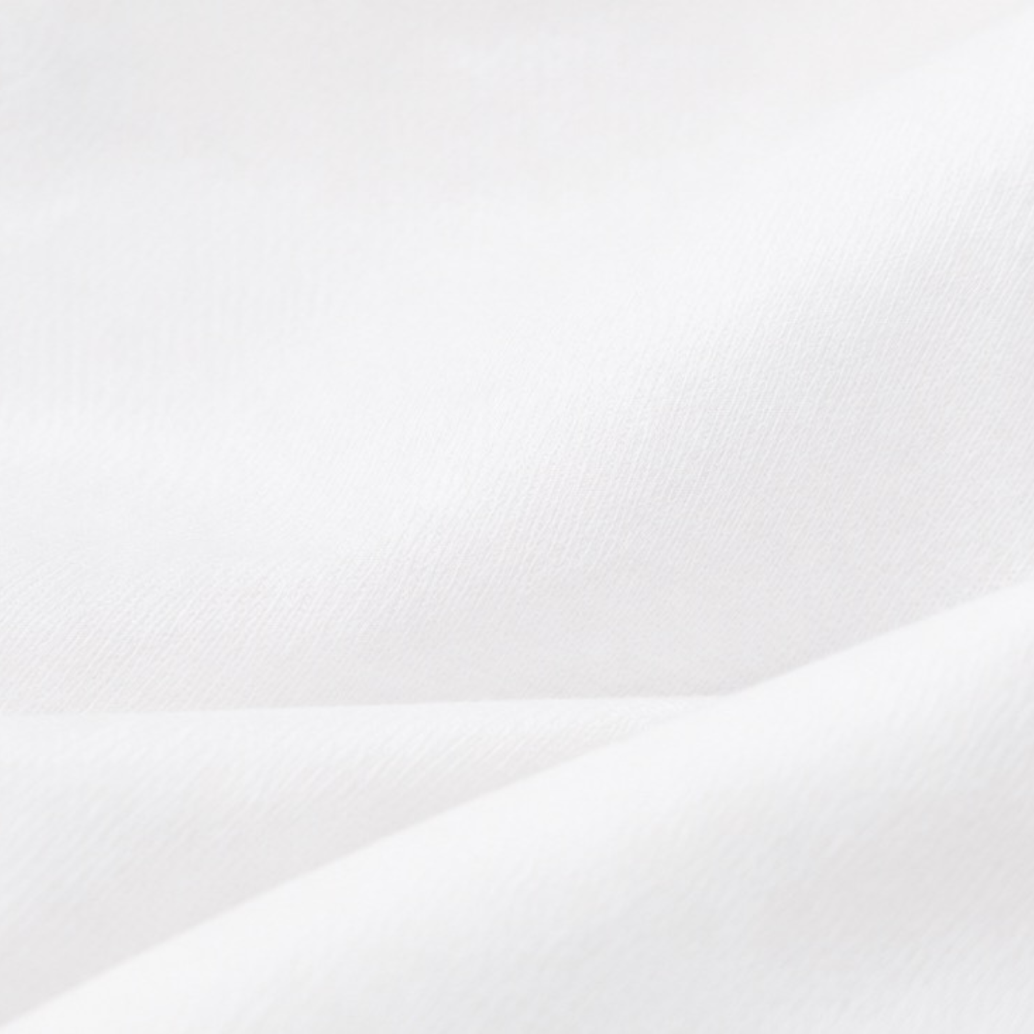 A close-up of white fabric with soft folds and a smooth texture.